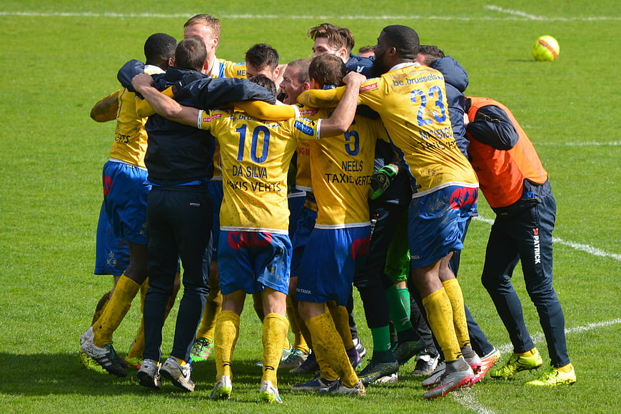Soccer team celebrating victory in yellow and blue jerseys