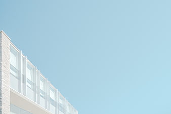 Modern white building facade against clear blue sky