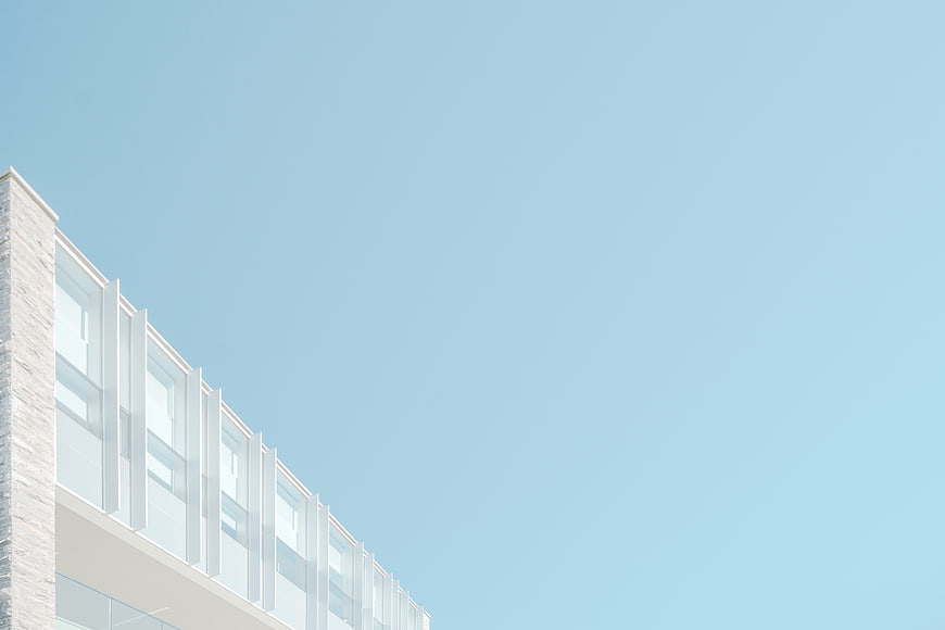 Modern white building facade against clear blue sky
