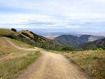 Dirt Trail Winding Through Golden Hills with Distant Valley View