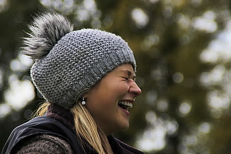 Laughing Woman Wearing Grey Knit Beanie With Pom Pom