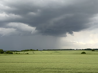 Dramatic Storm Clouds Over Green Rolling Countryside Fields