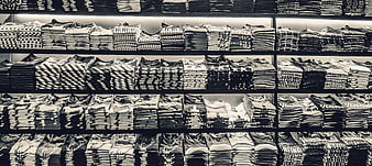 Black and white shelves of folded t-shirts in a clothing store