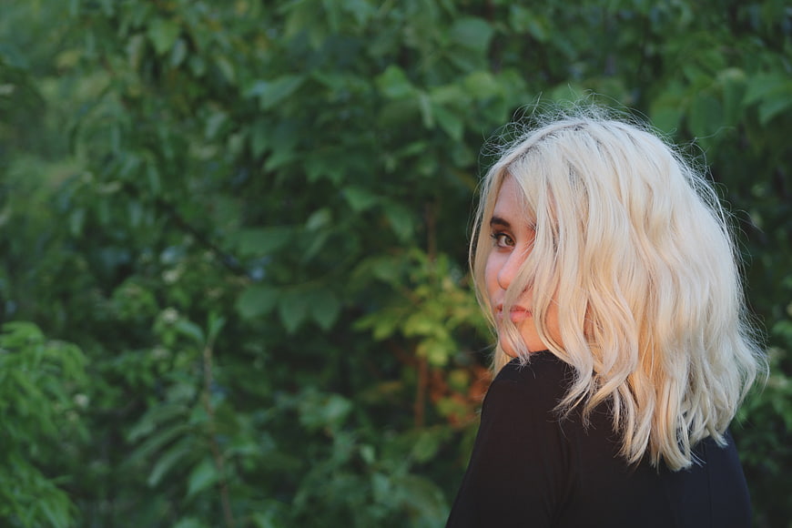 Blonde Woman Looking Back in Green Garden