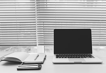 Black and white office desk with laptop and notebook