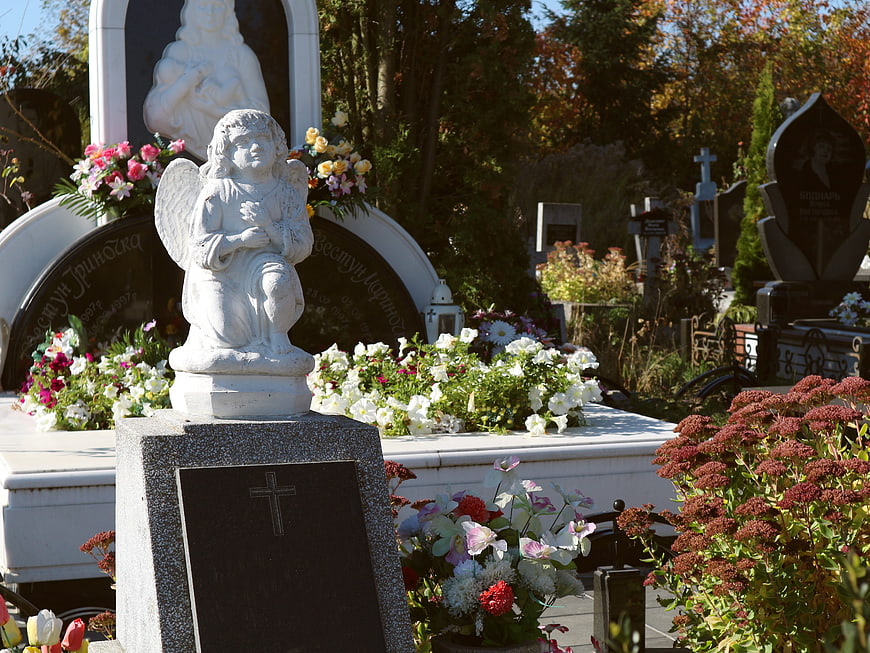 White Angel Statue on Grave in Autumn Cemetery