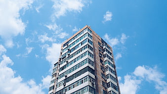 Low angle view of tall apartment building against blue sky