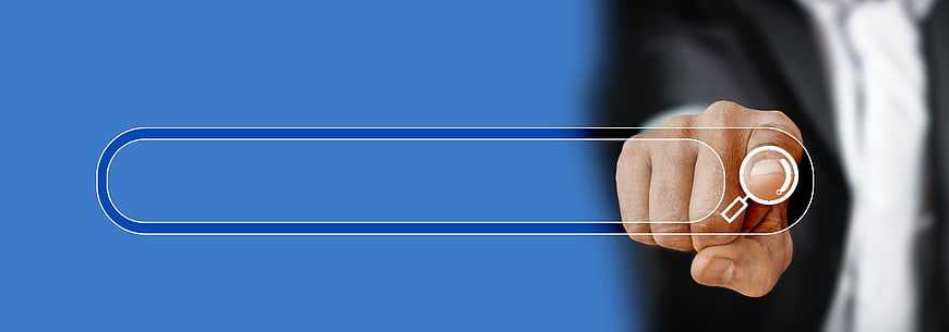 Businessman hand using magnifying glass search icon on blue background