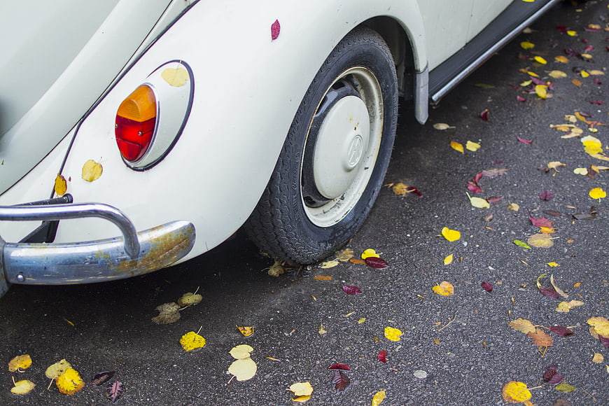 Vintage White Volkswagen Beetle Rear Wheel in Autumn Leaves