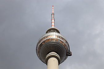 Low angle view of Berlin TV Tower against cloudy sky