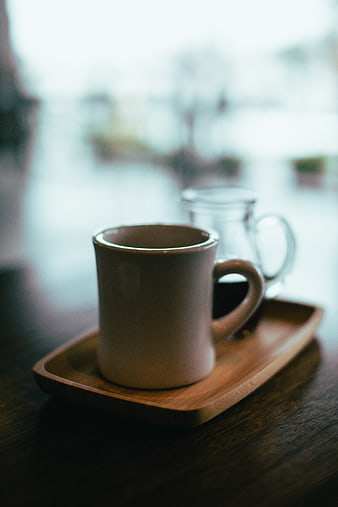 Ceramic coffee mug on wooden tray in cafe
