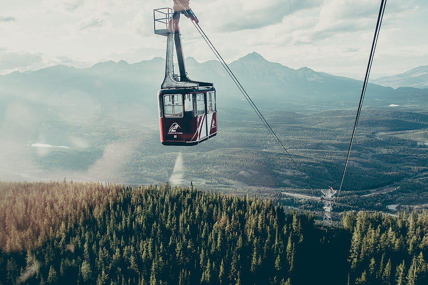 Red Gondola Lift Over Mountain Forest Landscape