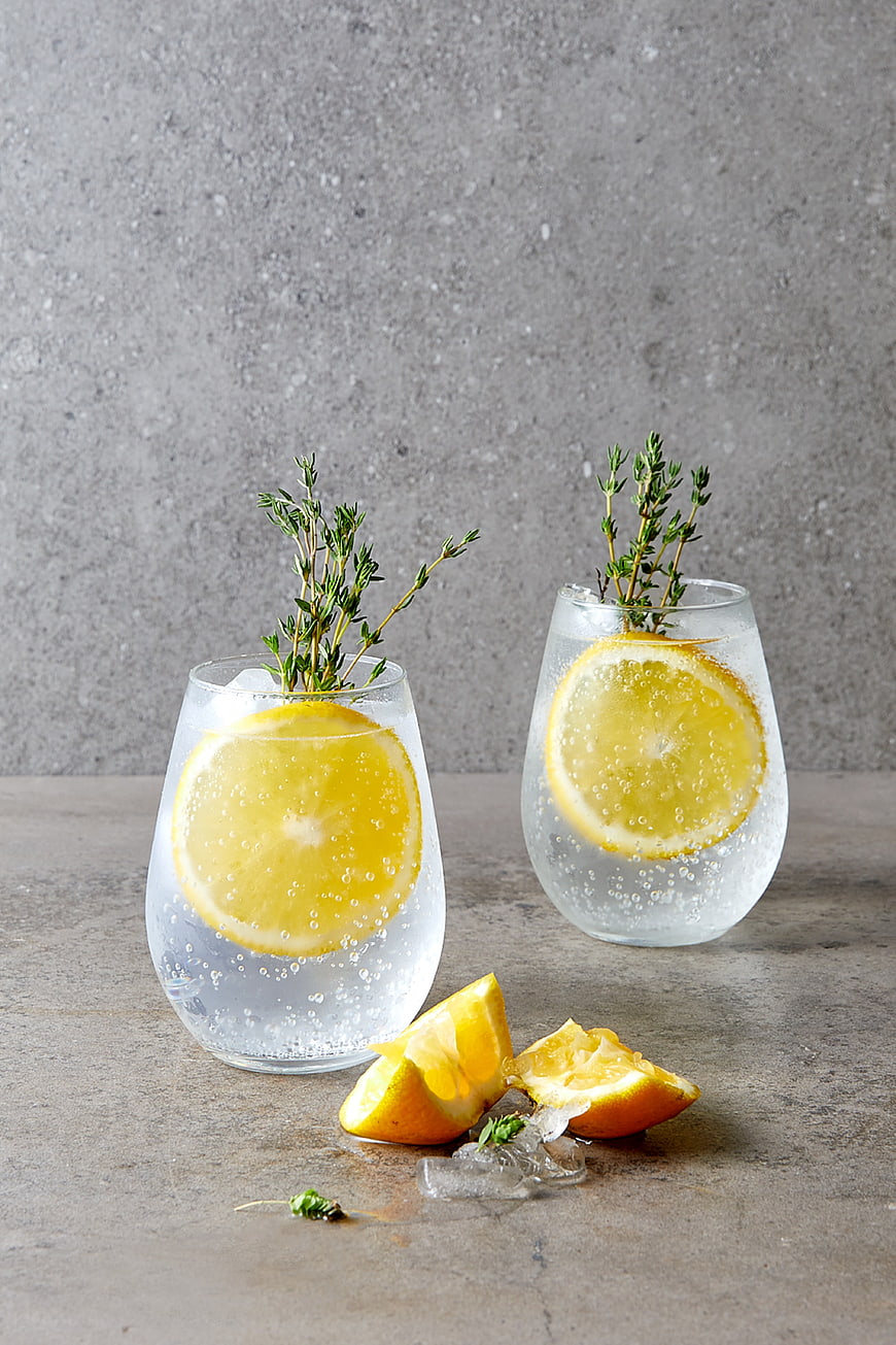 Refreshing Gin and Tonic with Orange and Thyme on Concrete