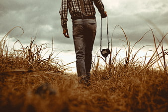 Photographer Walking Through Tall Grass with Camera