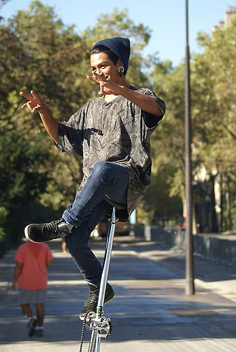 Young man performing unicycle trick outdoors