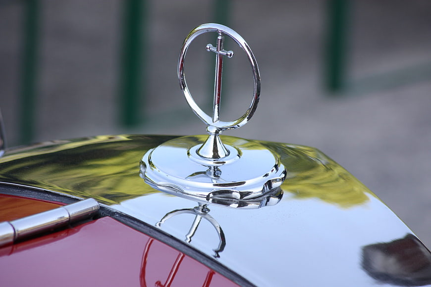 Close-up of vintage car hood ornament with chrome finish