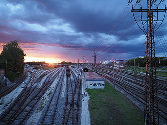 Dramatic sunset over railway tracks with freight train
