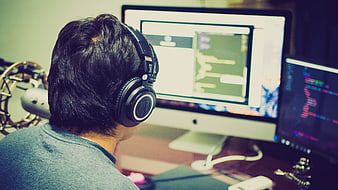 Programmer coding on dual monitors in a home office