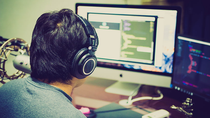 Programmer coding on dual monitors in a home office