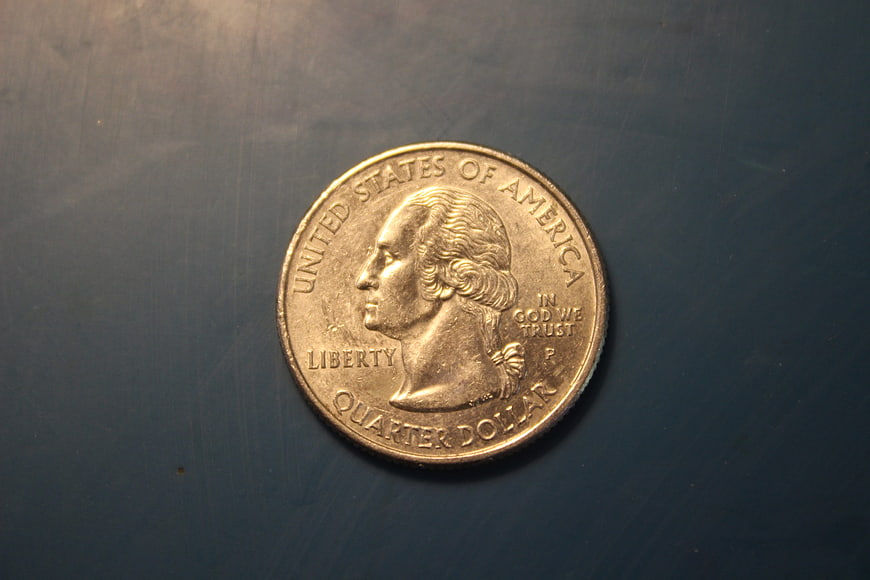 Close-up of a United States Quarter Dollar Coin on Dark Blue Surface