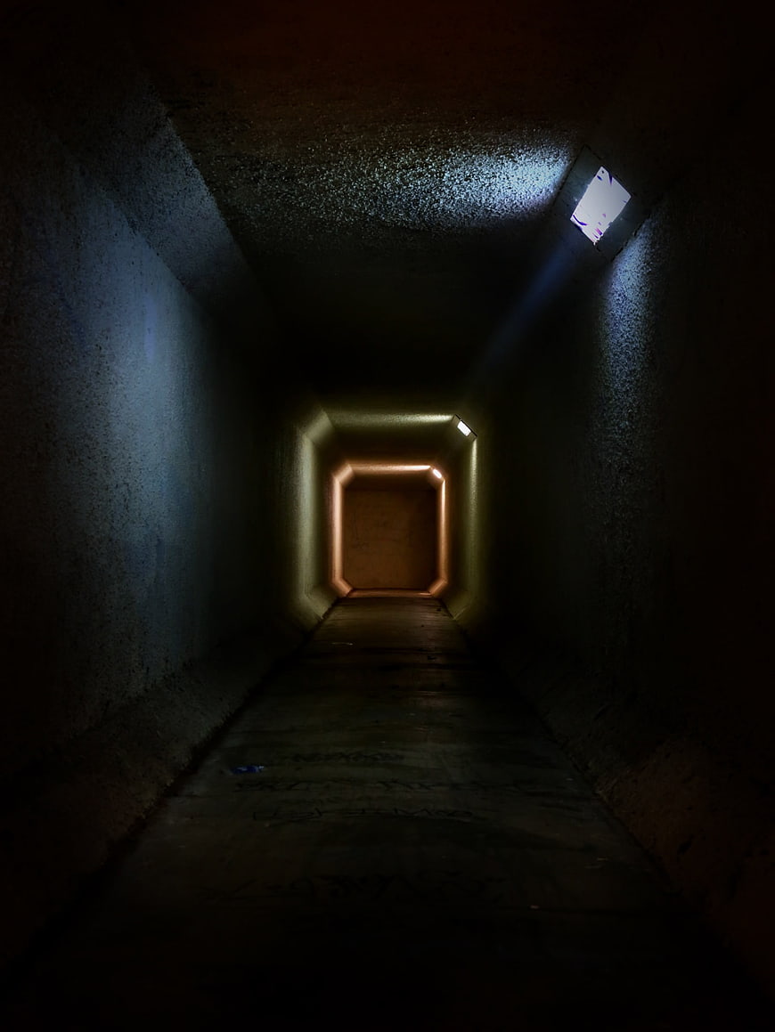 Dark concrete tunnel with mysterious light at the end