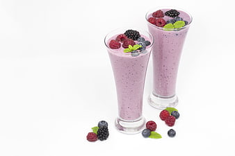 Two Berry Smoothies With Fresh Fruit Garnish On White Background