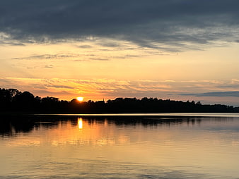 Serene Sunset Over Lake with Golden Reflections and Silhouetted Trees