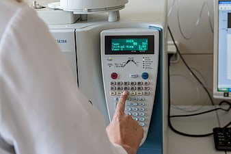 Scientist operating laboratory equipment control panel