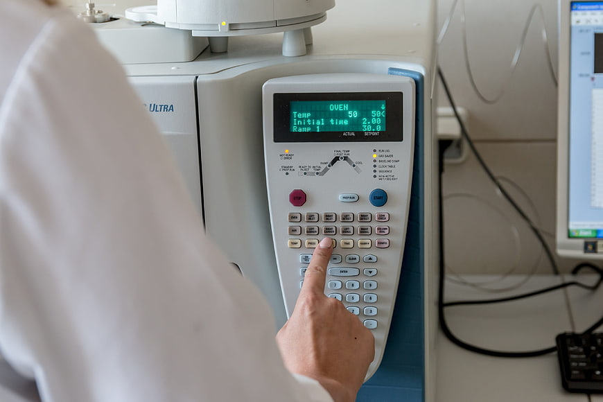 Scientist operating laboratory equipment control panel