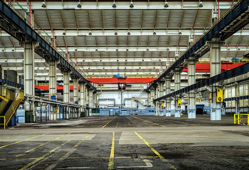 Empty Industrial Warehouse Interior with Red Crane