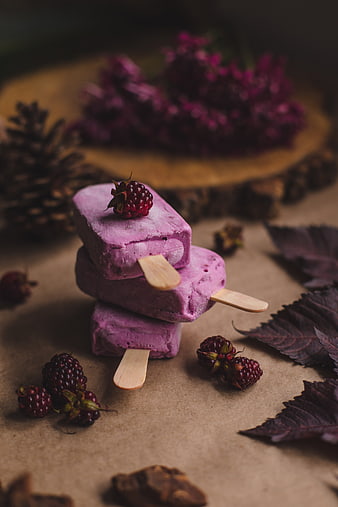 Stacked purple berry popsicles with fresh blackberries and leaves