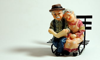 Ceramic figurine of elderly couple reading on a bench