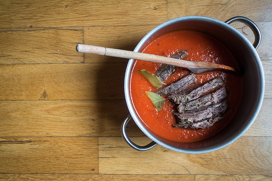 Top view of beef stew in pot with tomato sauce