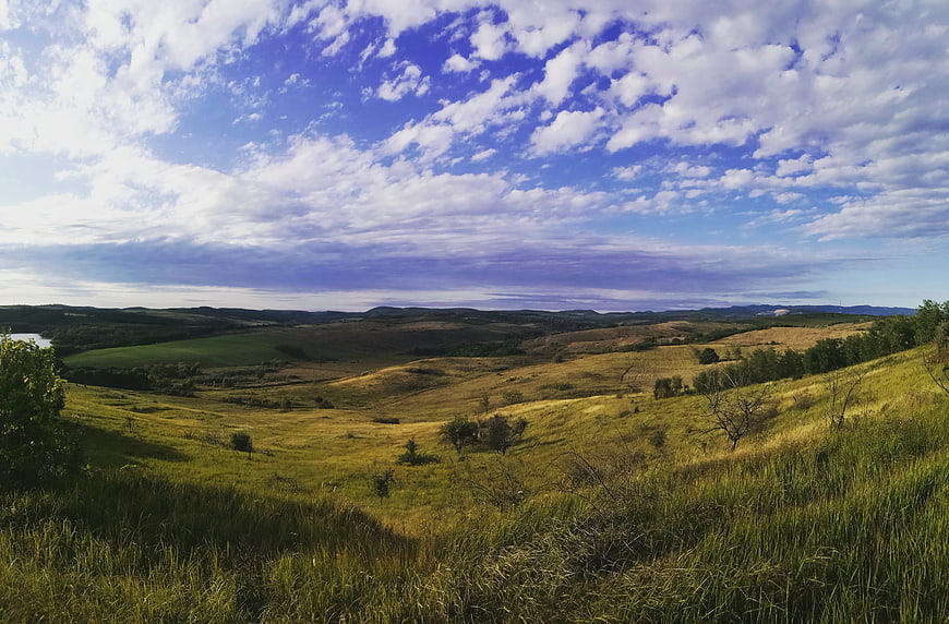 Rolling green hills and blue sky with clouds