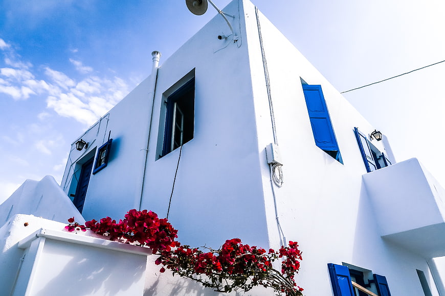 White Cycladic Architecture with Blue Shutters and Red Bougainvillea