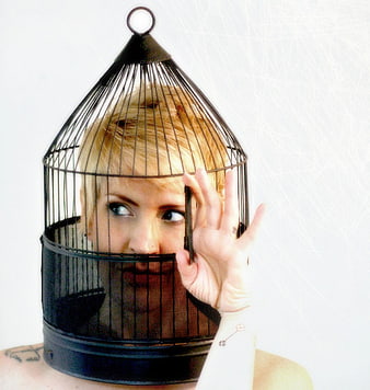 Woman with birdcage on head conceptual portrait
