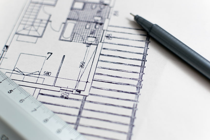 Architectural blueprint with pen and ruler on white background