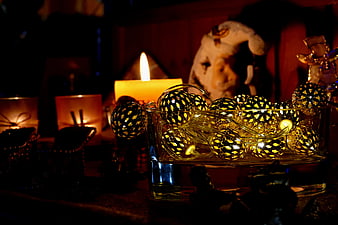 Golden Christmas Ornaments in Glass Bowl with Candlelight