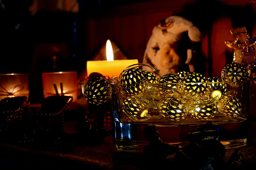 Golden Christmas Ornaments in Glass Bowl with Candlelight
