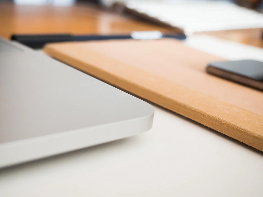Close-up of laptop corner and cork desk organizer