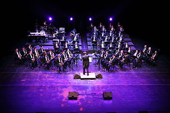 Big Band Orchestra Performing on Stage with Conductor