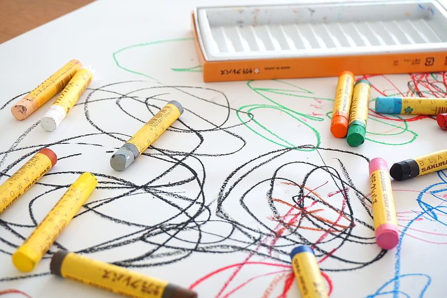 Colorful Crayons And Scribbles On White Paper