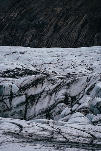 Dramatic glacier landscape with dark volcanic rock ridges