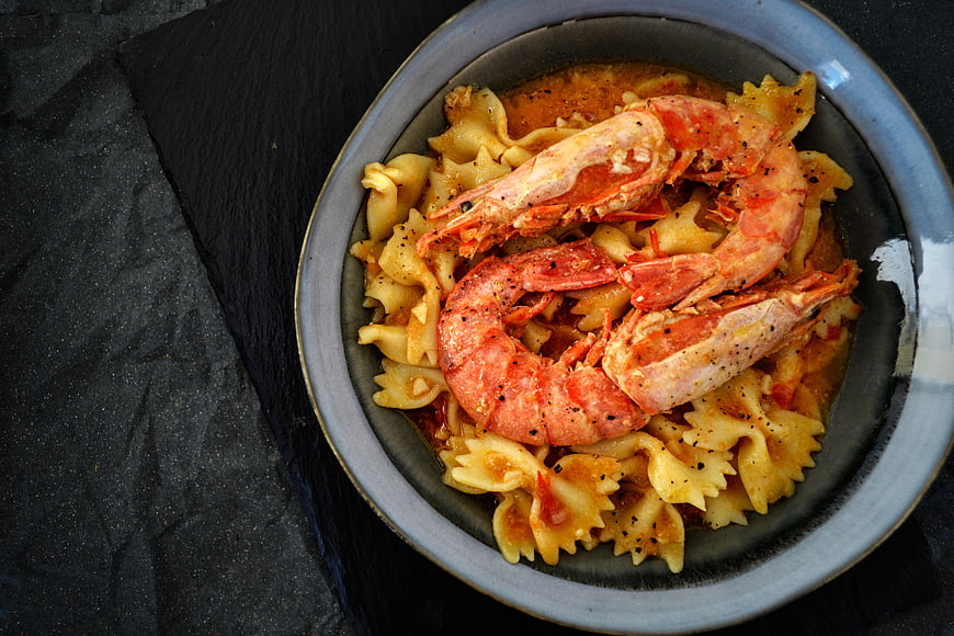 Overhead view of bowtie pasta with shrimp in tomato sauce