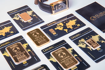 Gold bars and certificates with luxury watch on white background