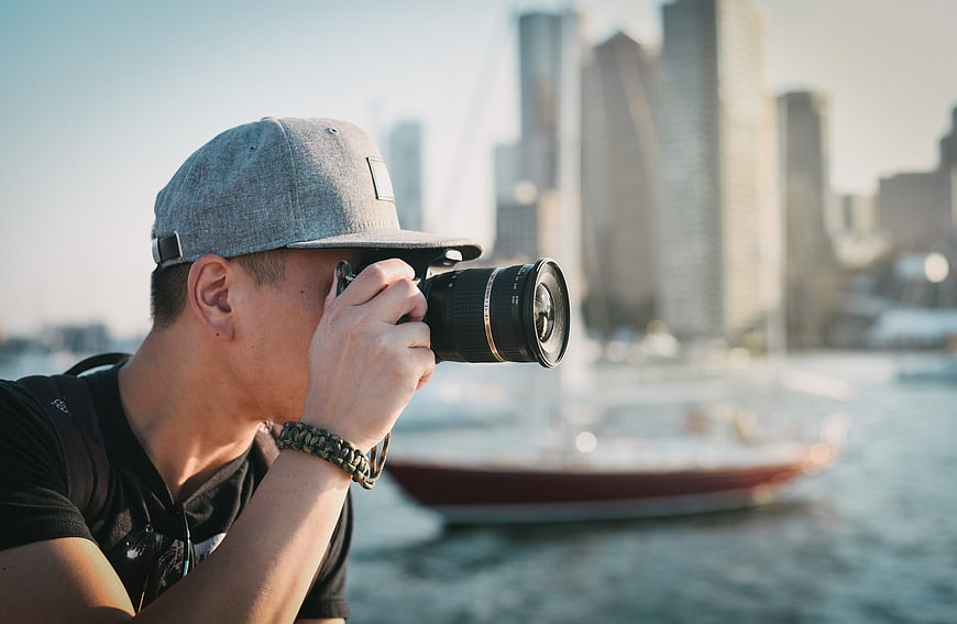 Man with Camera Photographing City Skyline by Water