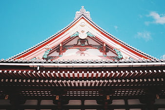 Traditional Japanese Temple Roof Architecture Against Blue Sky