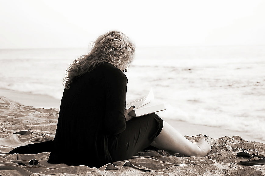Woman Reading Book on Sandy Beach Shore