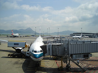 Cathay Pacific Airplane Parked At Airport Gate With Jet Bridge