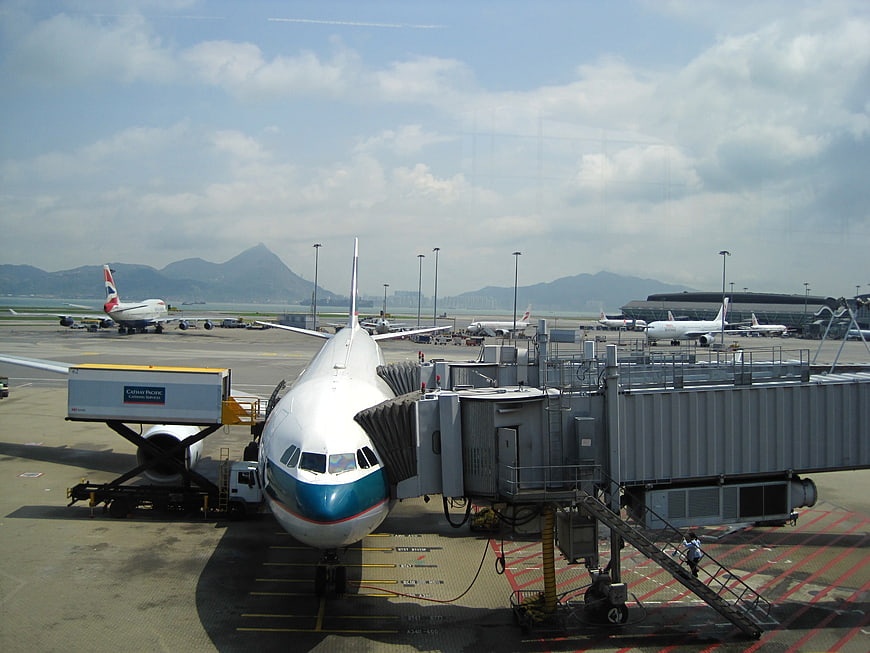 Cathay Pacific Airplane Parked At Airport Gate With Jet Bridge